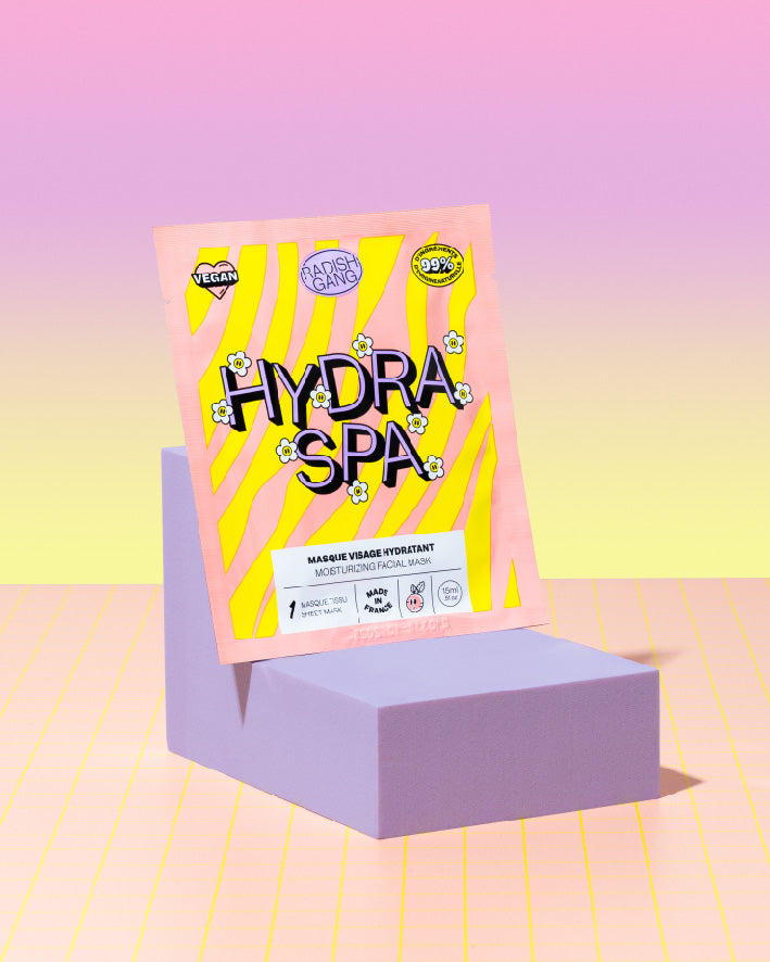 masque tissu hydratant présenté sur un socle avec en fond un dégradé de couleurs vives