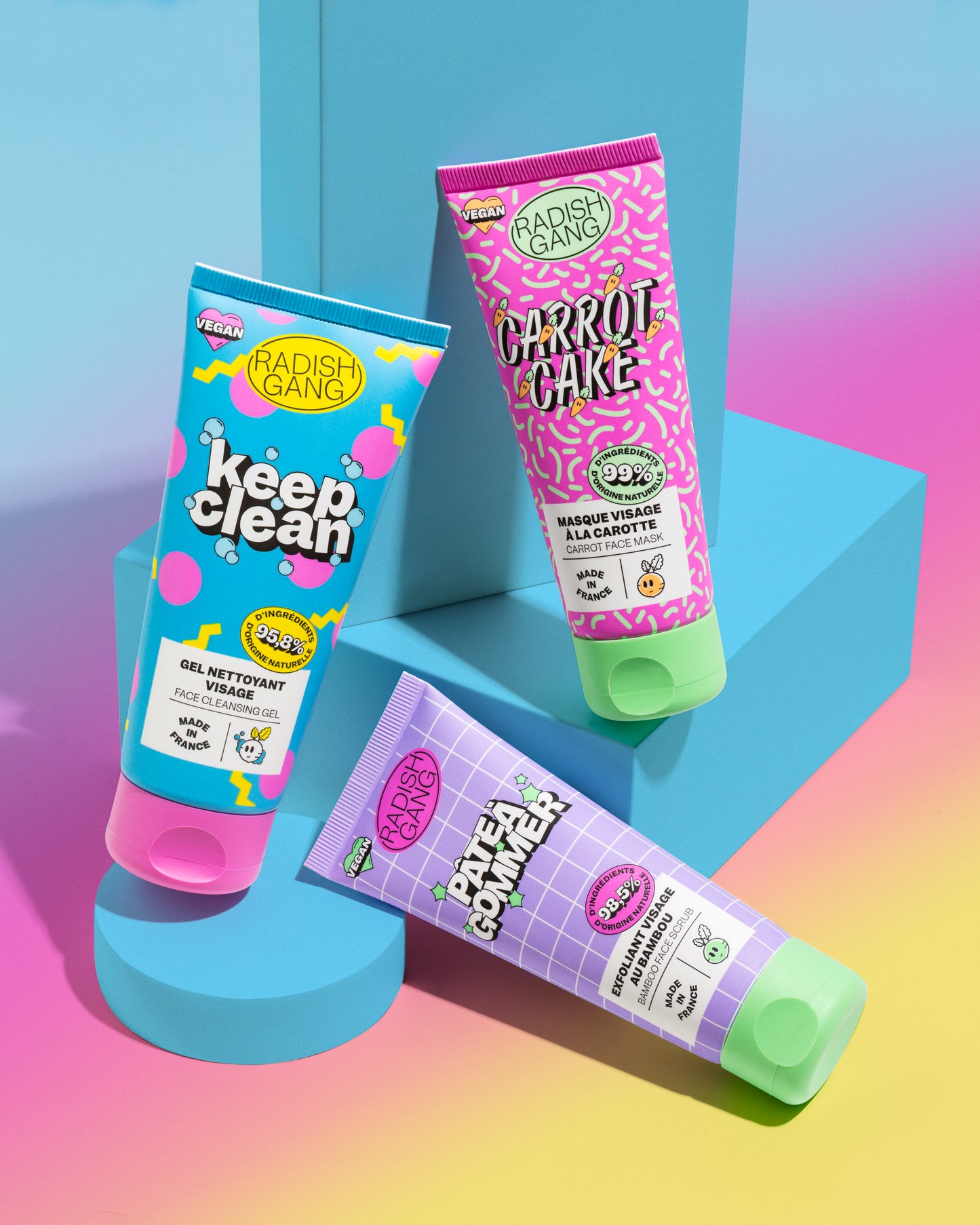 Présentation des trois produits keep clean, carrot cake et pâte à gommer posés sur des socles avec un fond coloré en dégradé de couleurs