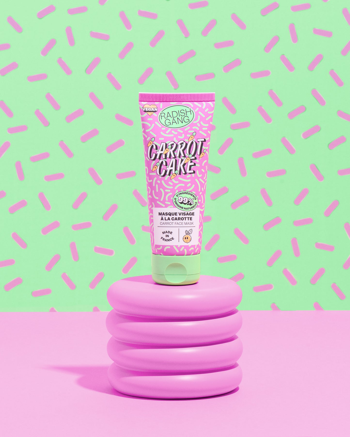 tube carrot cake présenté sur un socle avec un fond coloré à motifs